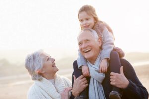 grandparents with grandchild on shoulders