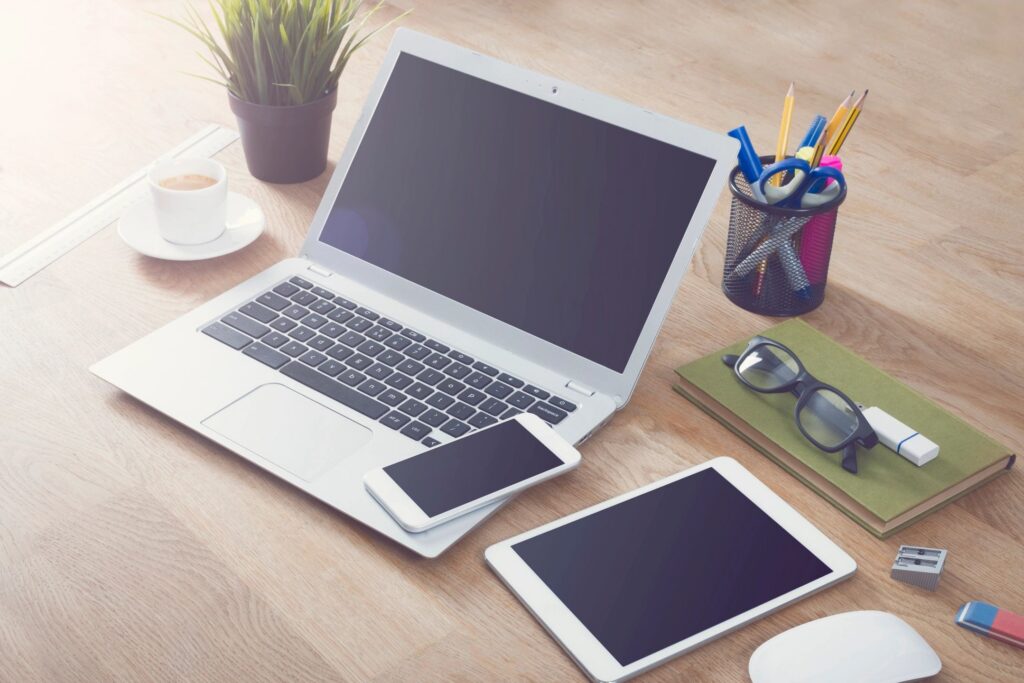 laptop, cell phone, and tablet on desk.
